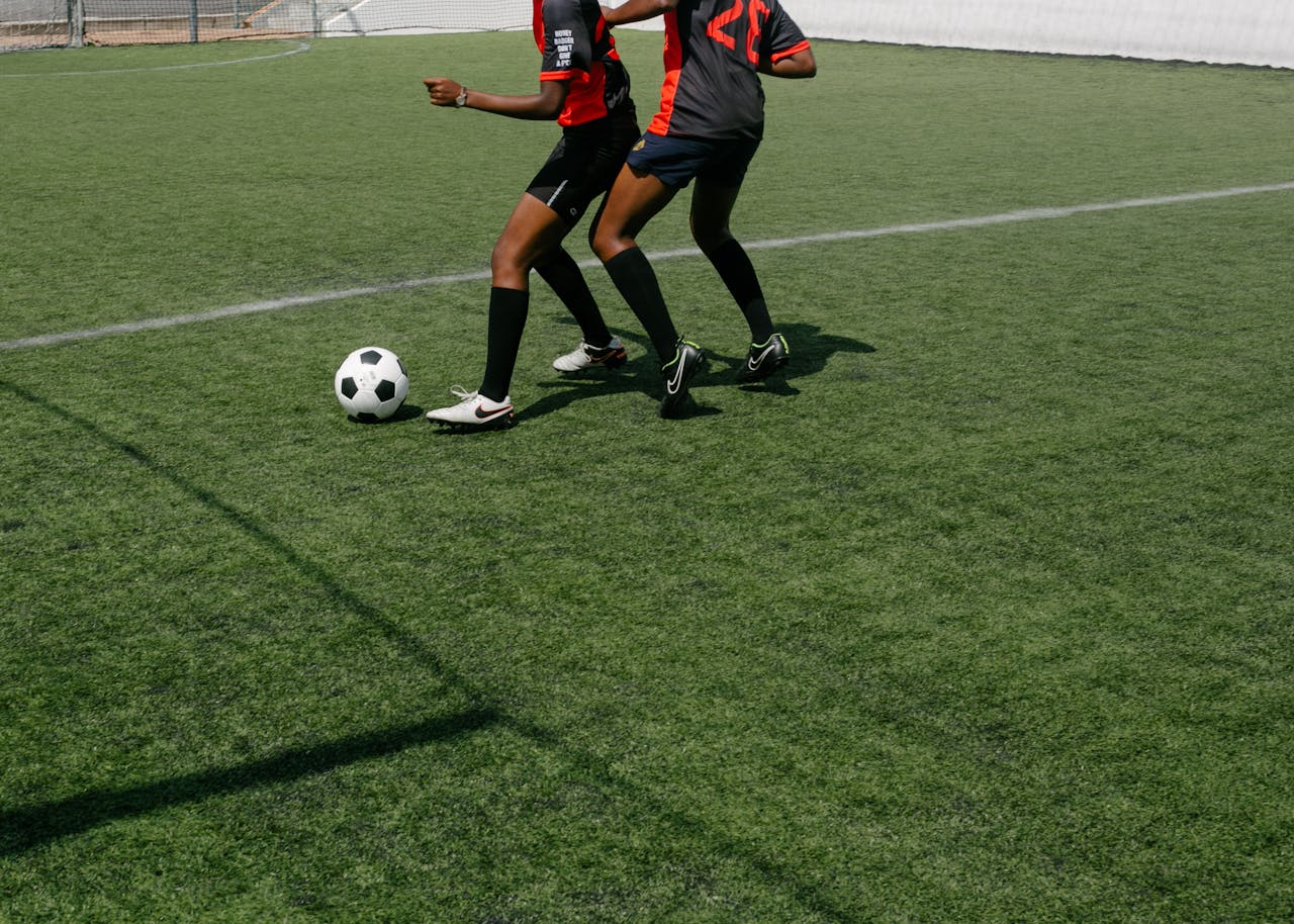 Faceless women soccer players fighting for ball