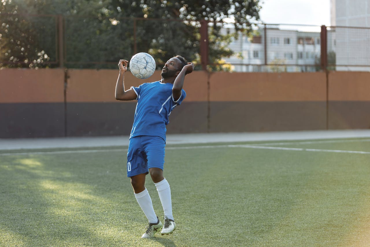Man in Blue Jersey Shirt and Shorts Playing Soccer